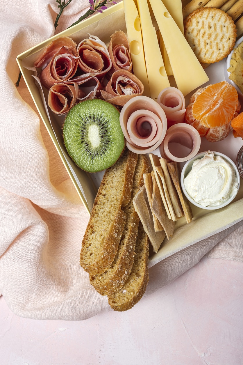 Sajt, keksz, gyümölcsök és zöldségek uzsonnás dobozban