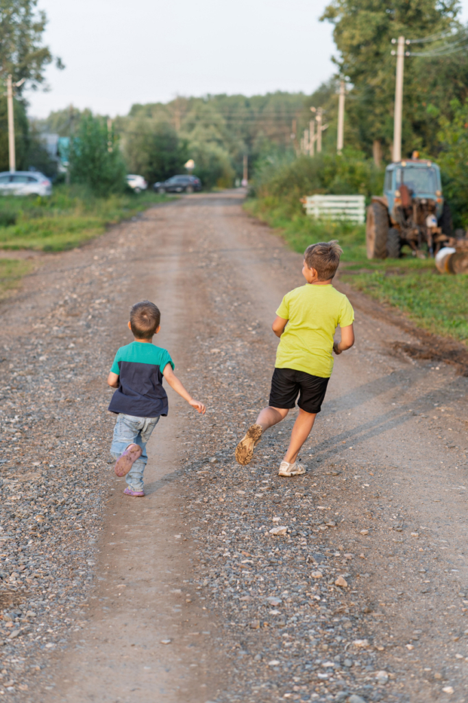 Children running on a dirt road in the Hungarian countryside