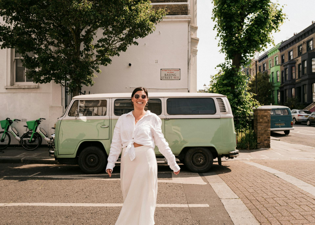 Donna che cammina verso un camper vintage in un parcheggio