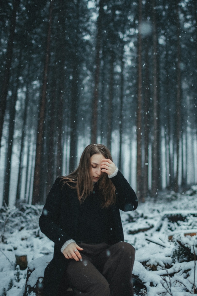 Csalódott, síró fiatal nő a téli erdőben