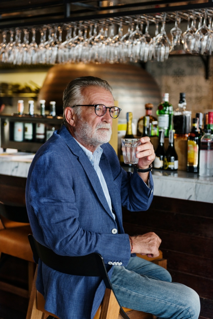 Középkorú férfi whiskey-t iszik egy bárban
