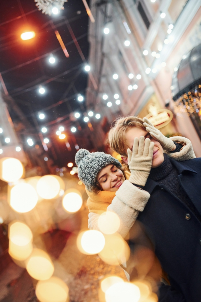 Une femme cache les yeux d’un homme dans l’effervescence de Noël