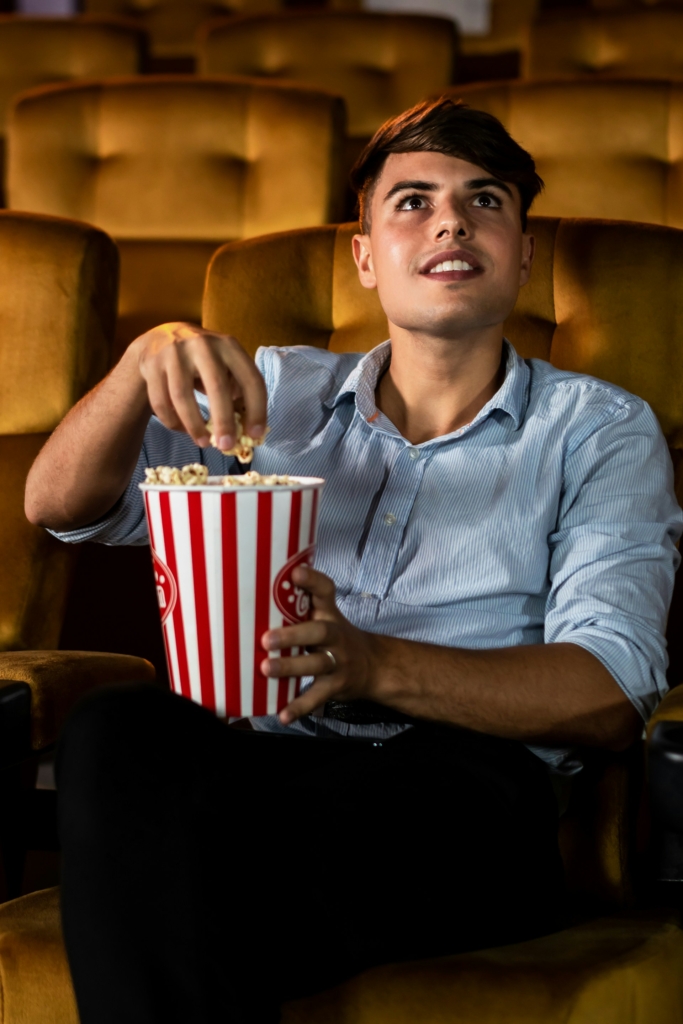 Fiatal srác popcorn-nal a kezében filmezik