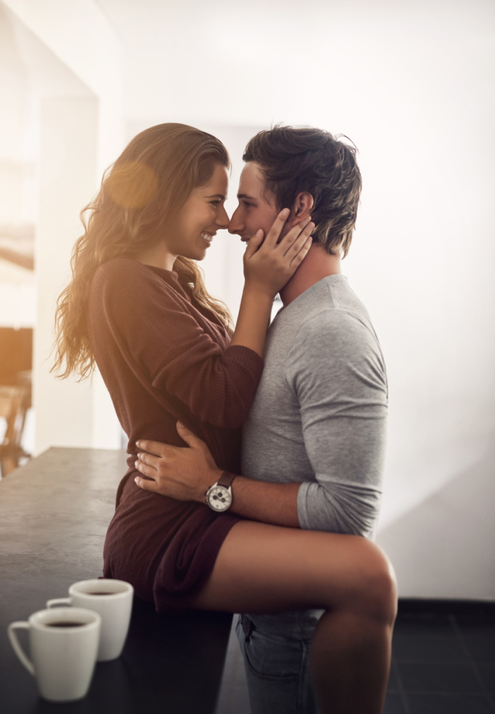 Nő és férfi csókolózik a konyhapulton