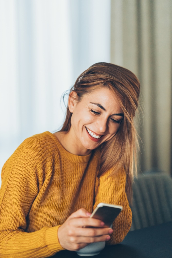 Fiatal nő görgeti a mobiltelefonját