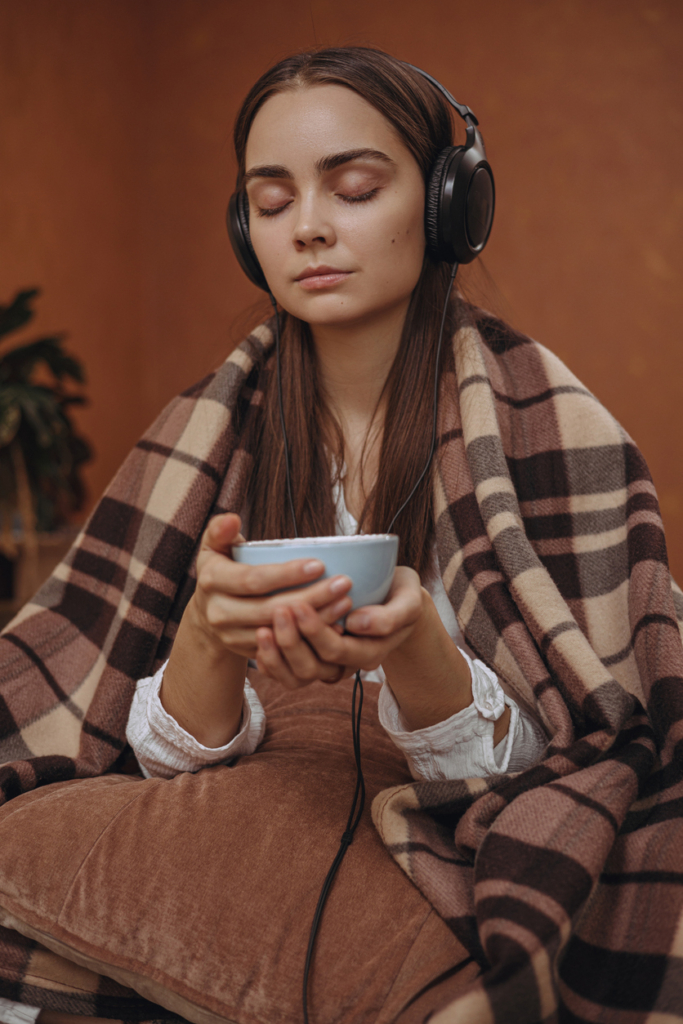 Femme écoutant de la musique en buvant un café