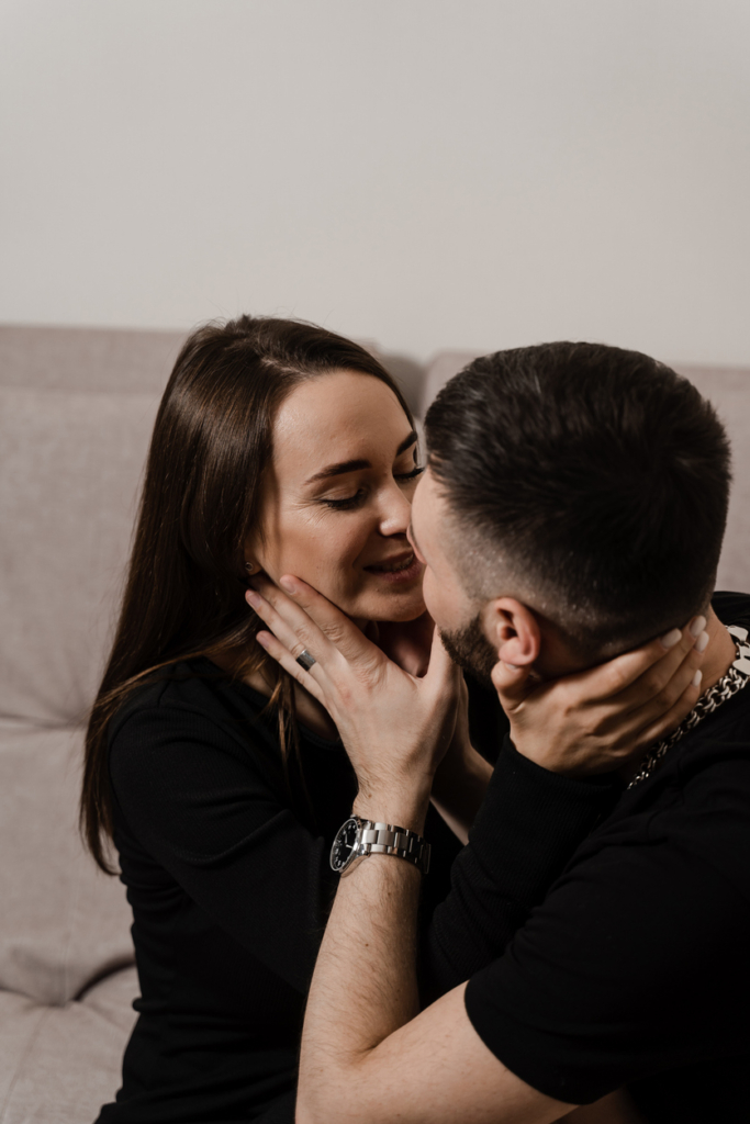 Fiú és lány fogja egymás arcát csókolózásra készen