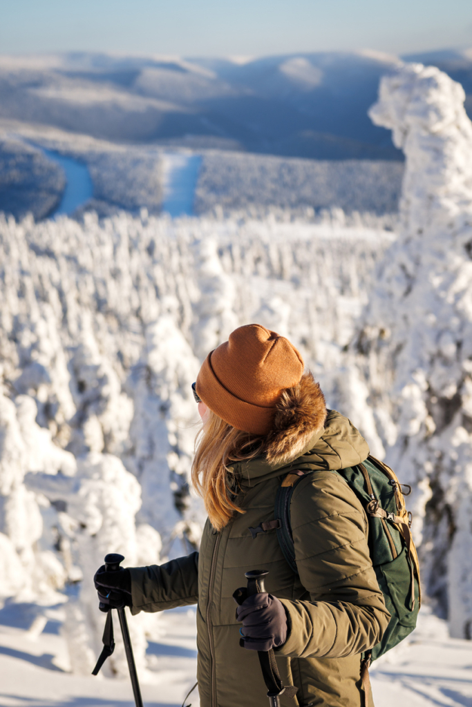Nő túrázik a havas hegyekben