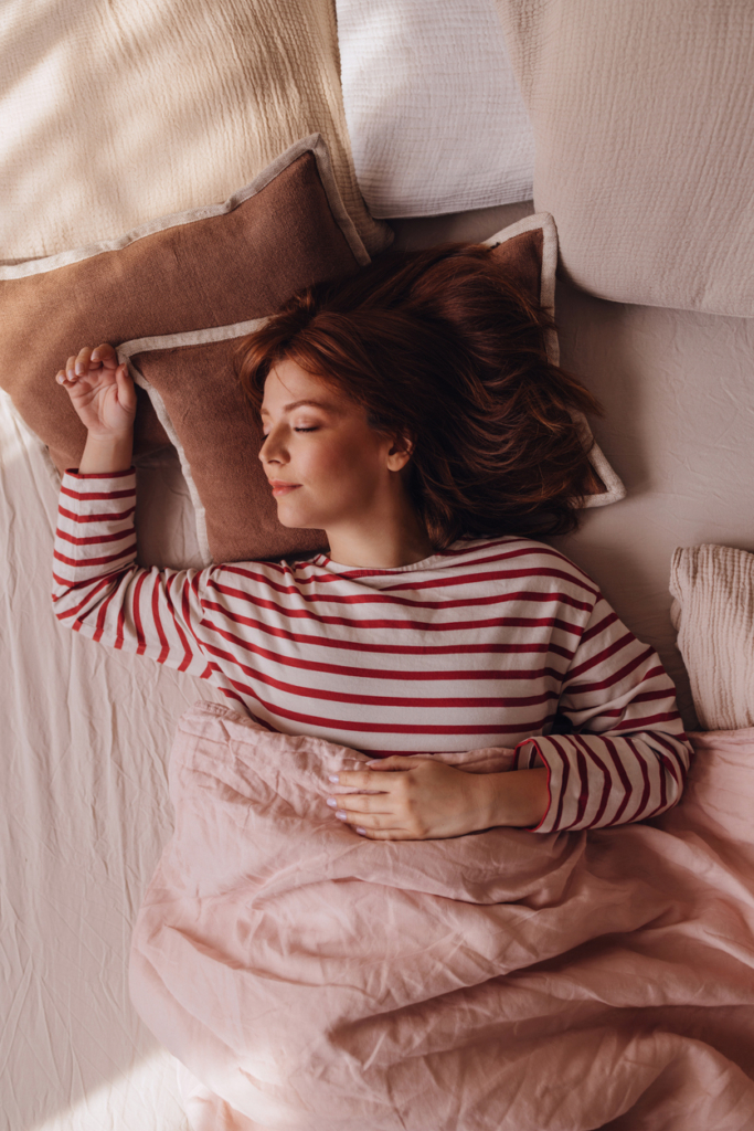 Nő pizsamában alszik az ágyban