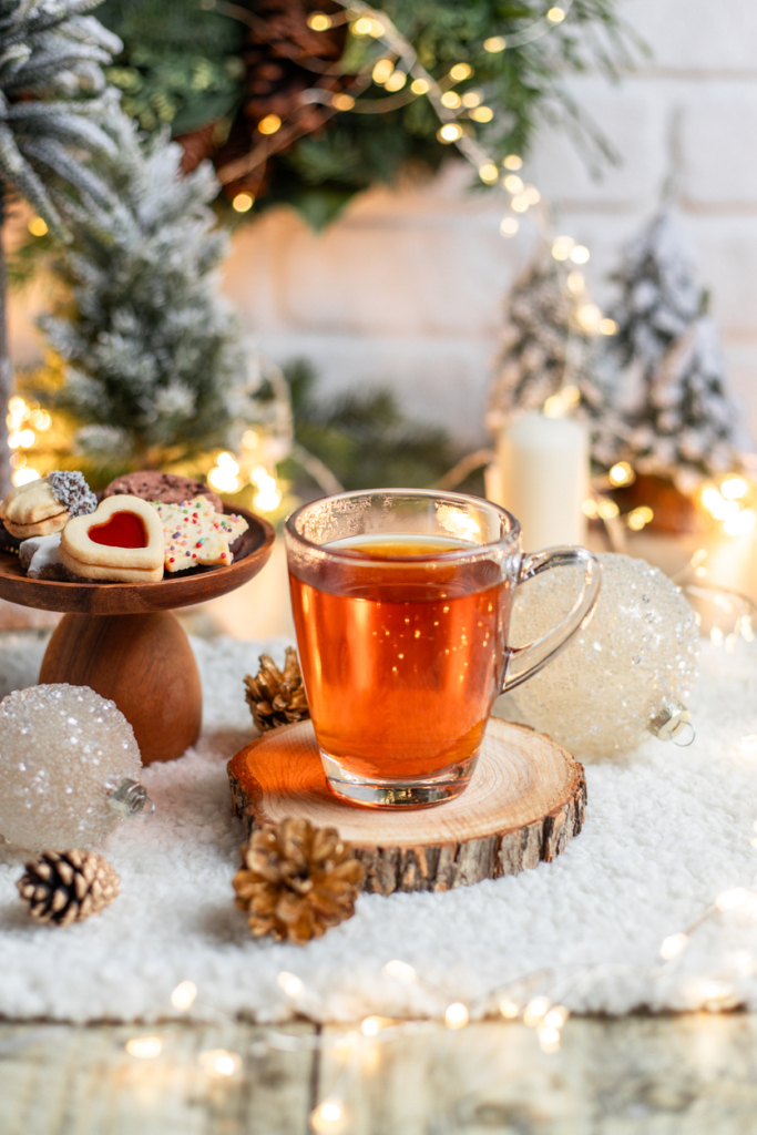 Gőzölgő forró tea és édes, omlós karácsonyi sütemények egy fahasábon