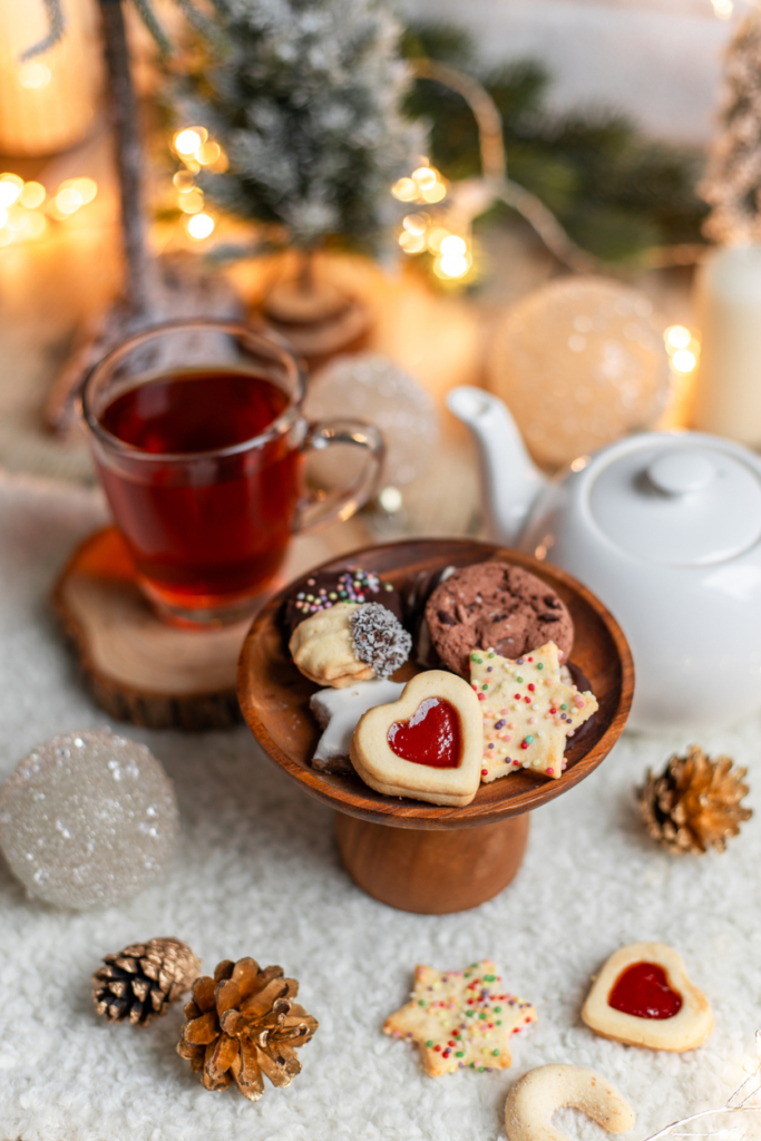 Tazza di tè caldo e piccoli biscotti natalizi