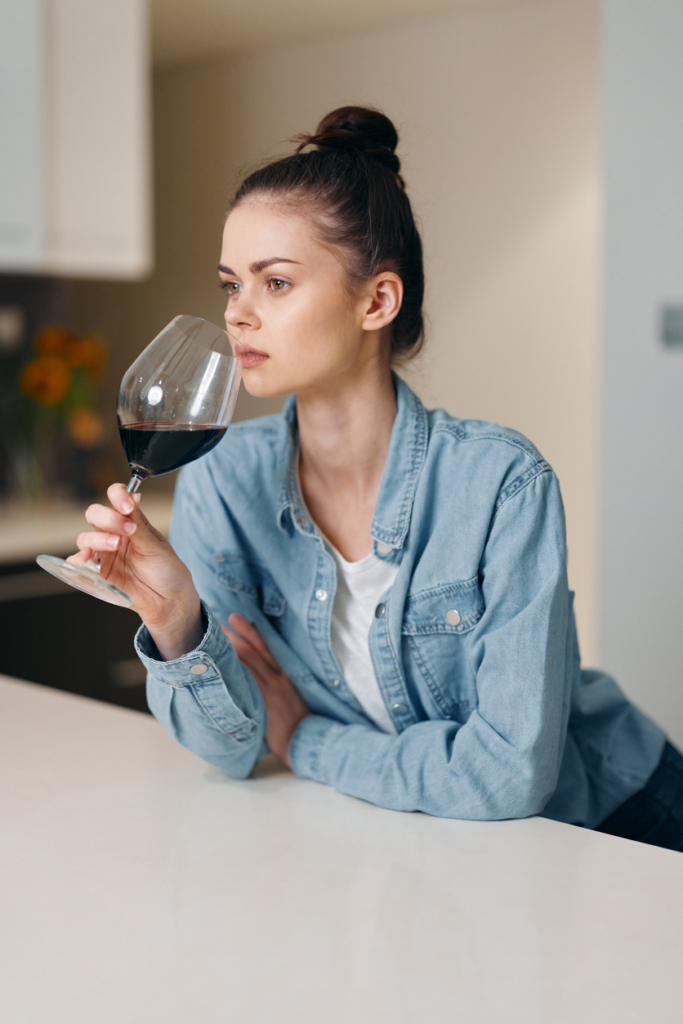 Nő egyedül borozik az asztalnál
