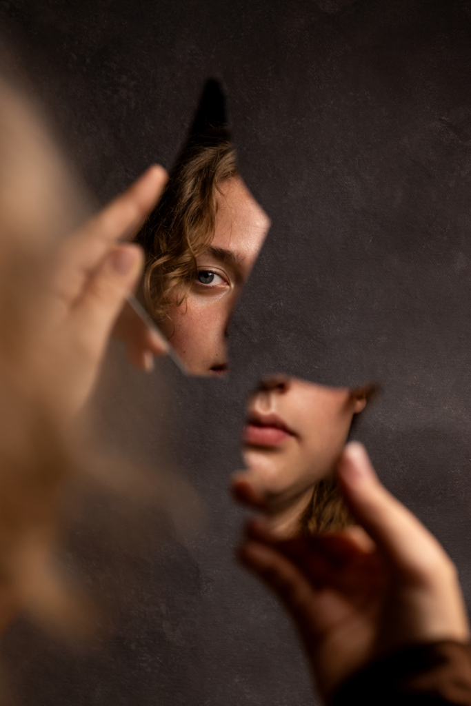 Nő egy törött tükörben nézi az arcát