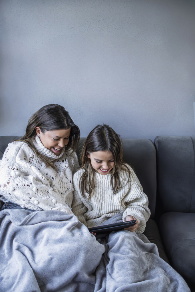 Anya és lánya takaróba csavarodva olvas a tableten