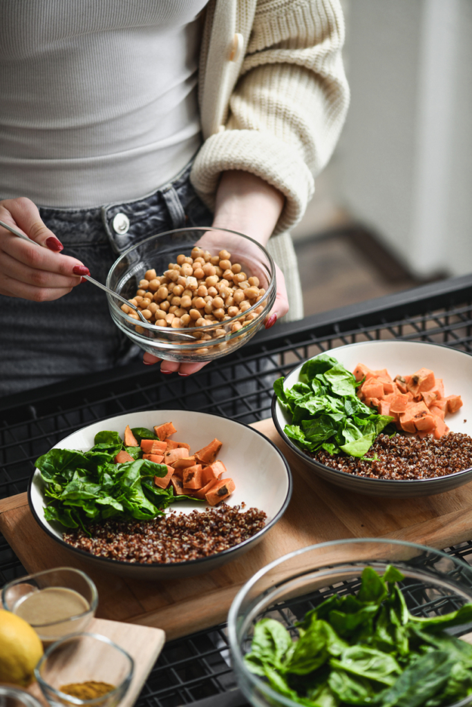 Nő egészséges buddha bowl-t készít friss zöldségekkel