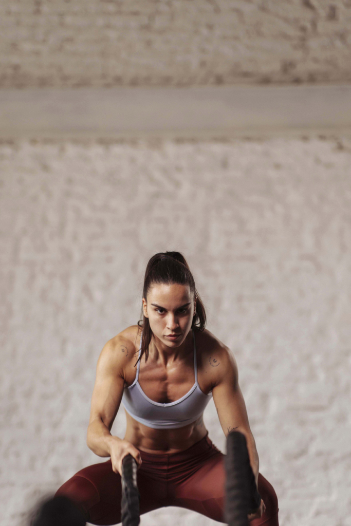 Izmos nő az edzőteremben edz kötelekkel