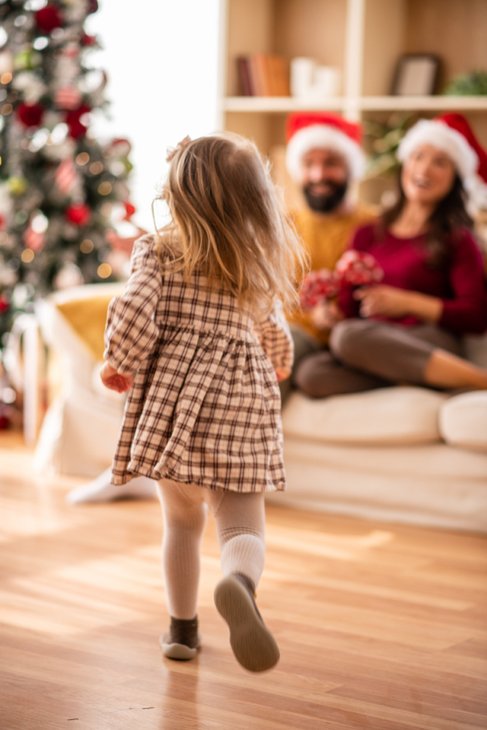Kislány szalad a szülei felé karácsonykor