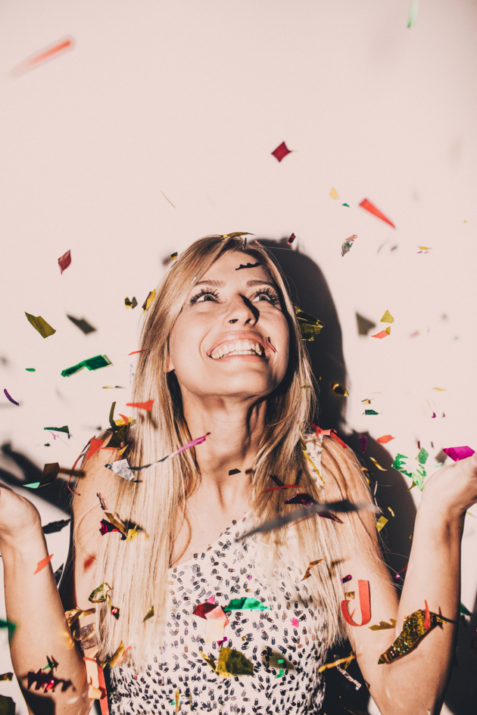 Nő szilveszterkor a konfettiesőben