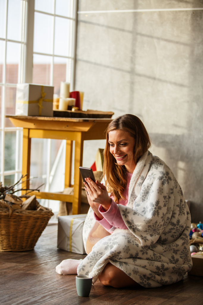 Nő videóhívást folytat a padlón ülve