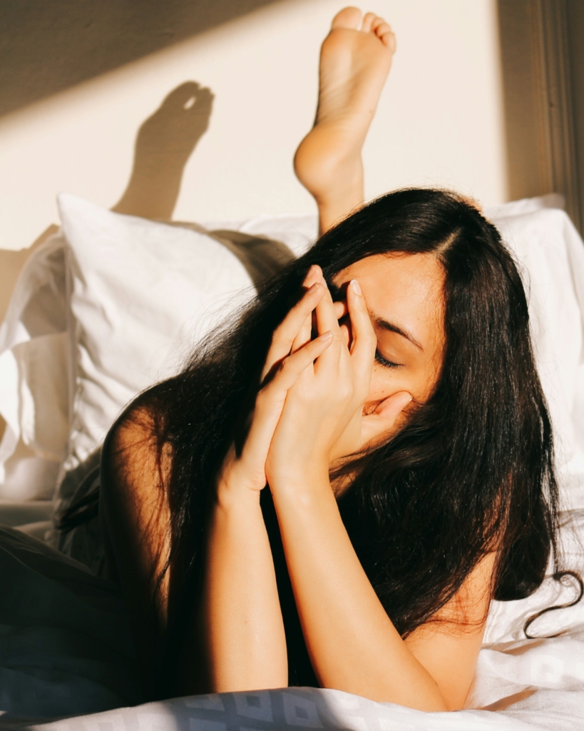Fáradt, stresszes nő az ágyban fekszik