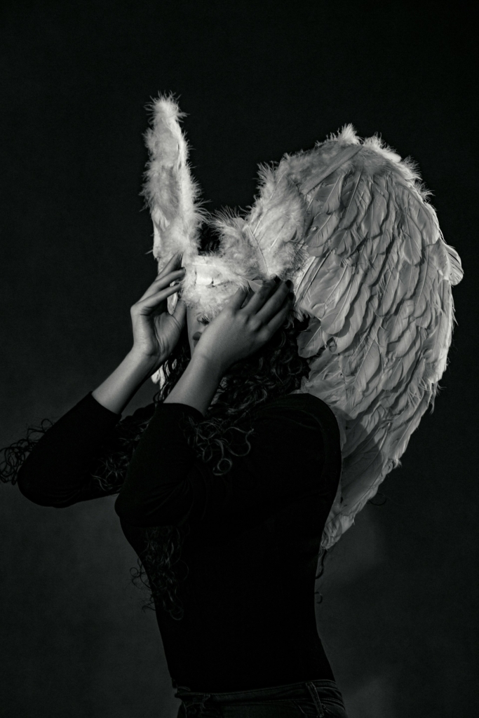 Nő fekete ruhában, angyal szárnyakkal a fején