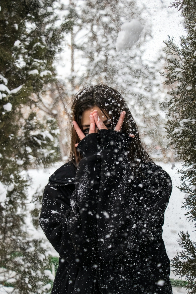 Hóesés, lány kukucskál az ujjain át
