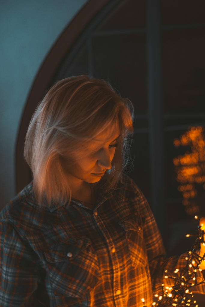 Nő a karácsonyfa izzót próbálja kibogozni