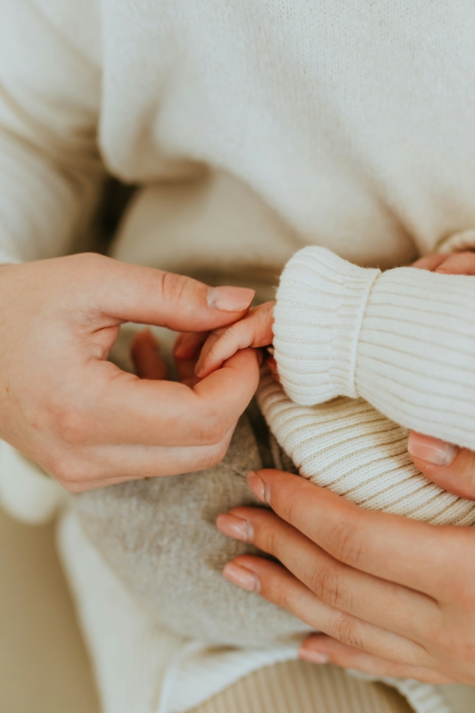 Anya a csecsemő kezét fogja