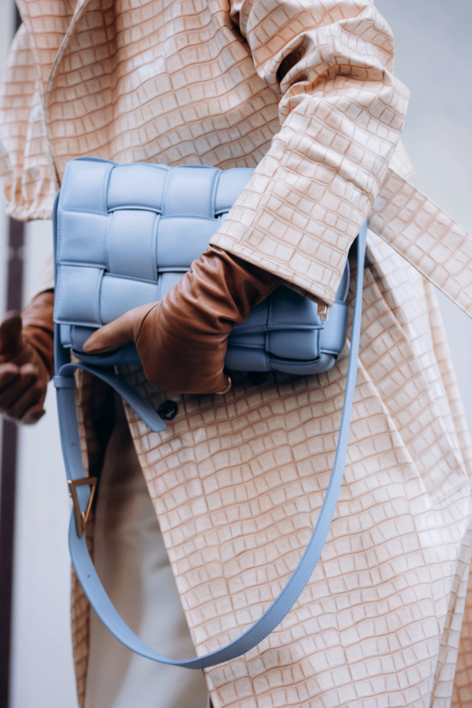 Nő a kezében fog egy táskát - street style fotó