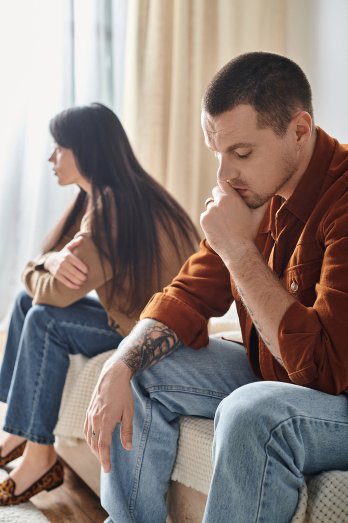 Fiatal, egymástól elhidegült szerelmespár ül az ágy két szélén