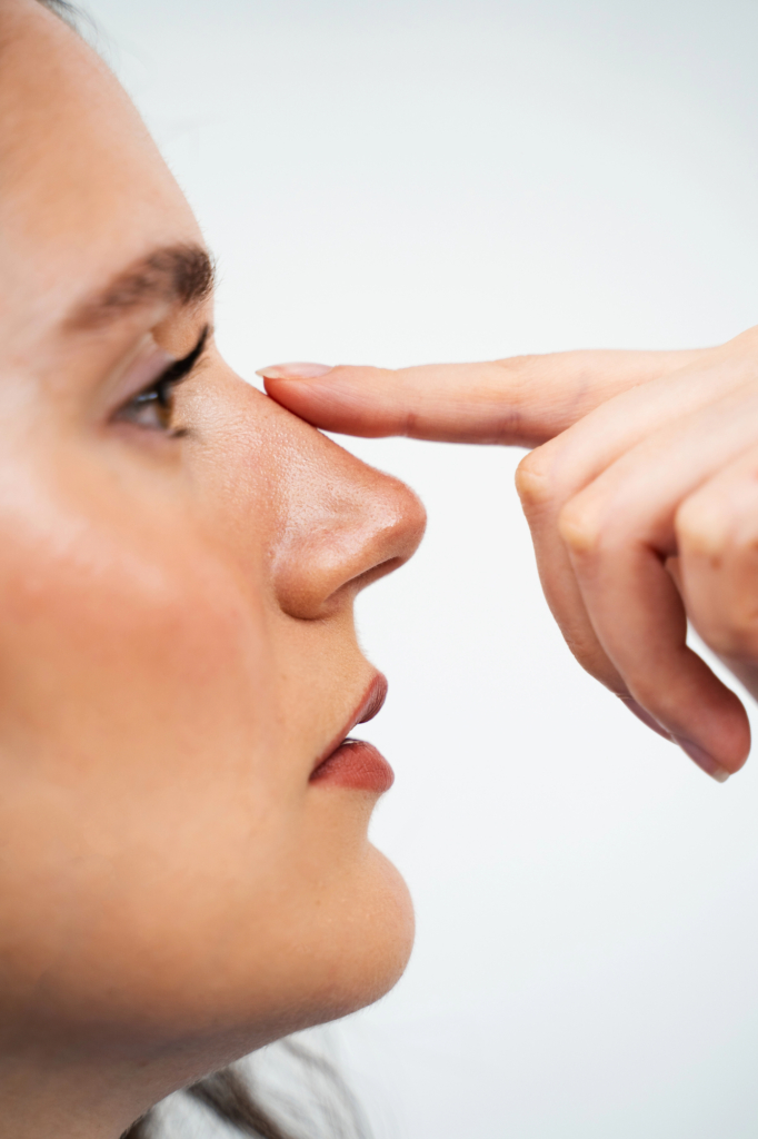 Fiatal lány megérinti az orrát