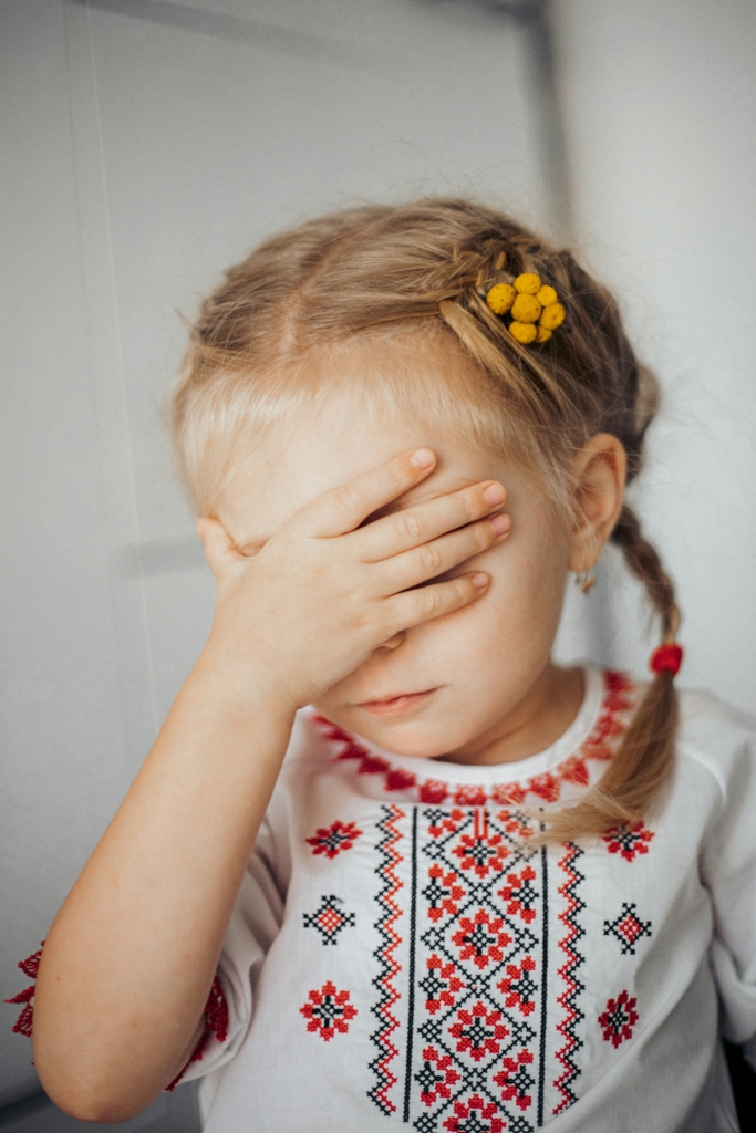 Fonott hajú kislány fogja a fejét