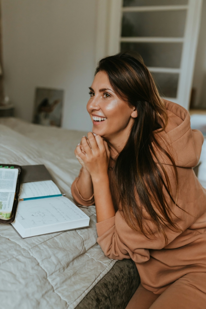 Nő örömmel ül a naplója mellett