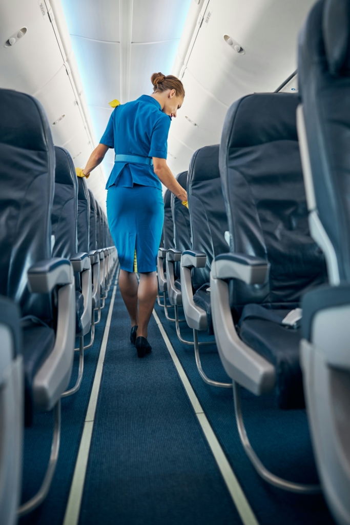 Stewardess sétál a repülőn a folyosón