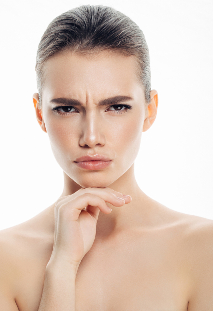 Lány ráncolt homlokkal és szemöldökkel, portré