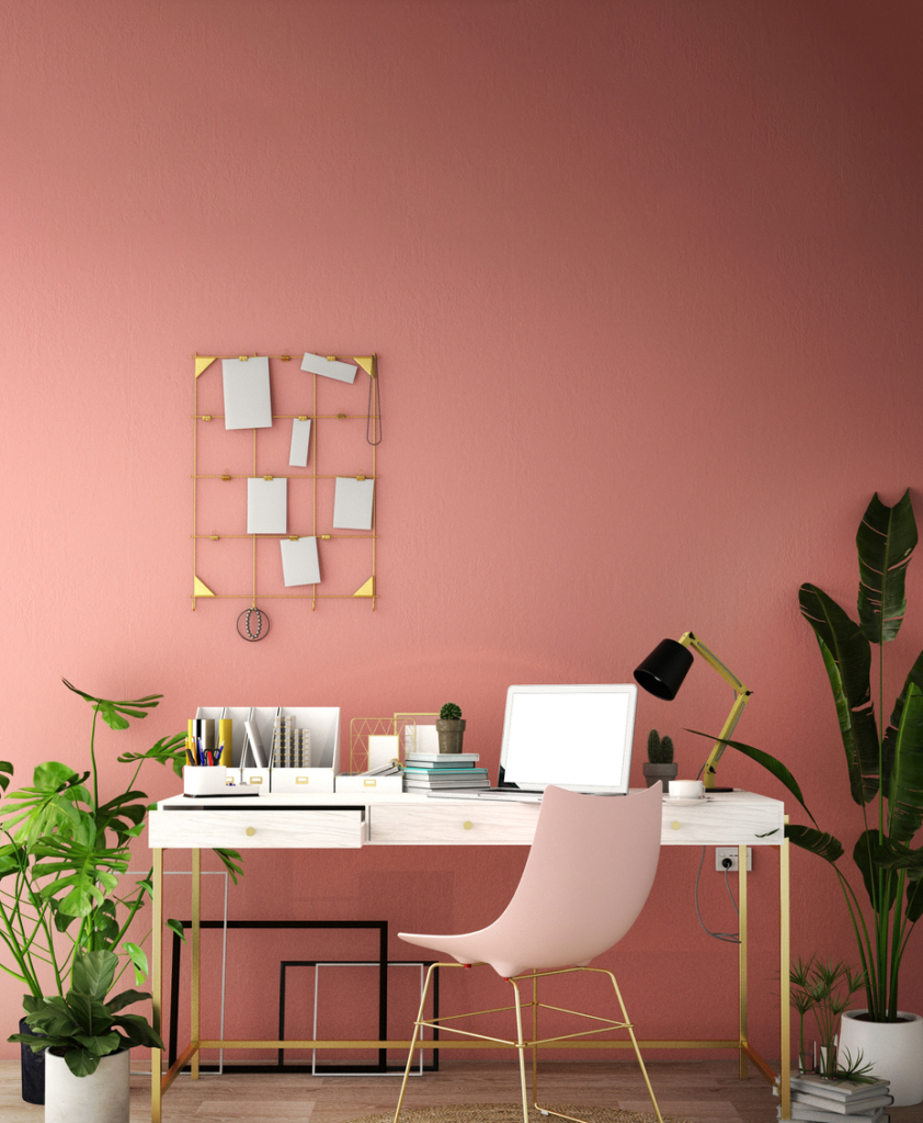 Dolgozósarok lazacszínű fallal, rózsaszín székkel, képekkel a falon