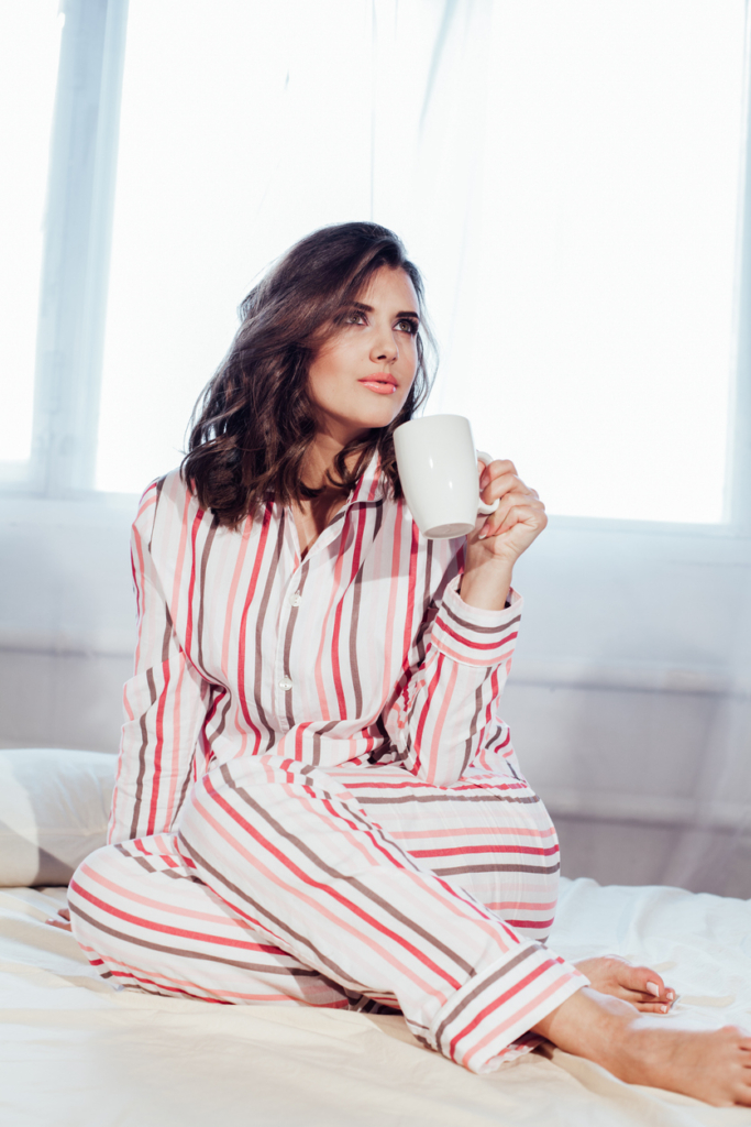 Nő pizsamában kávézik