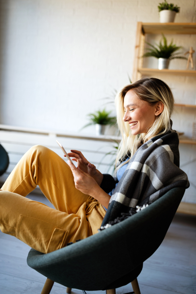 Fiatal nő mosolyog a karosszékben