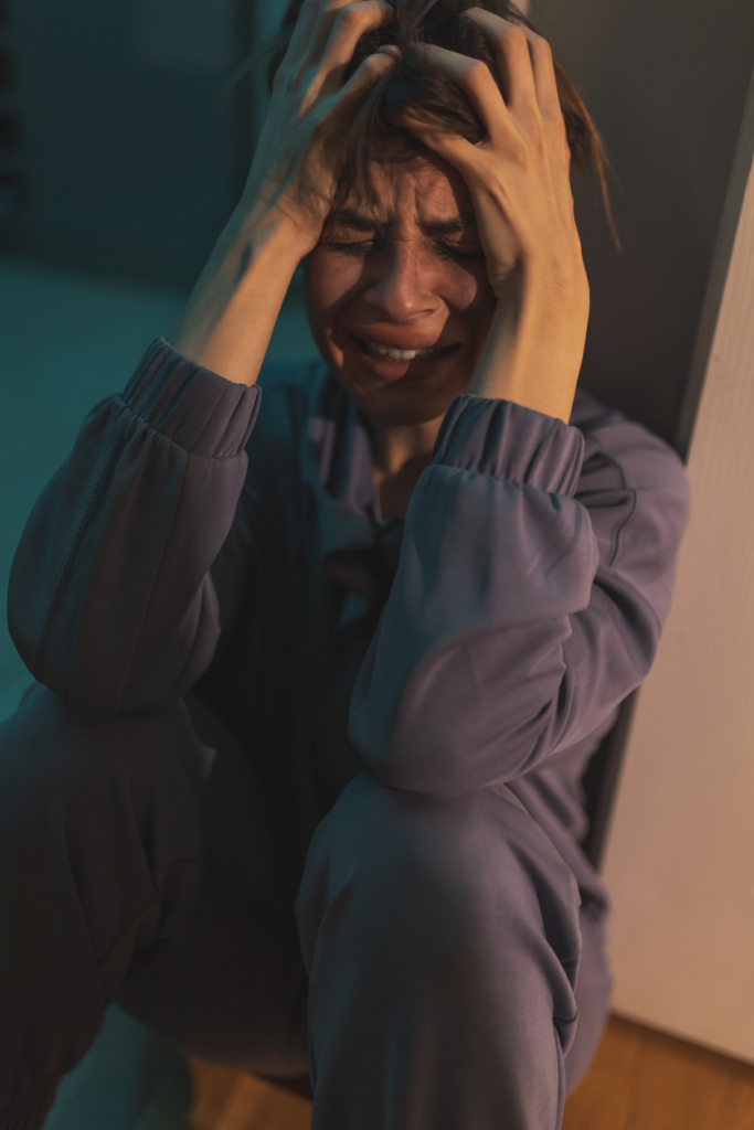 Síró nő összeomolva a földön ül