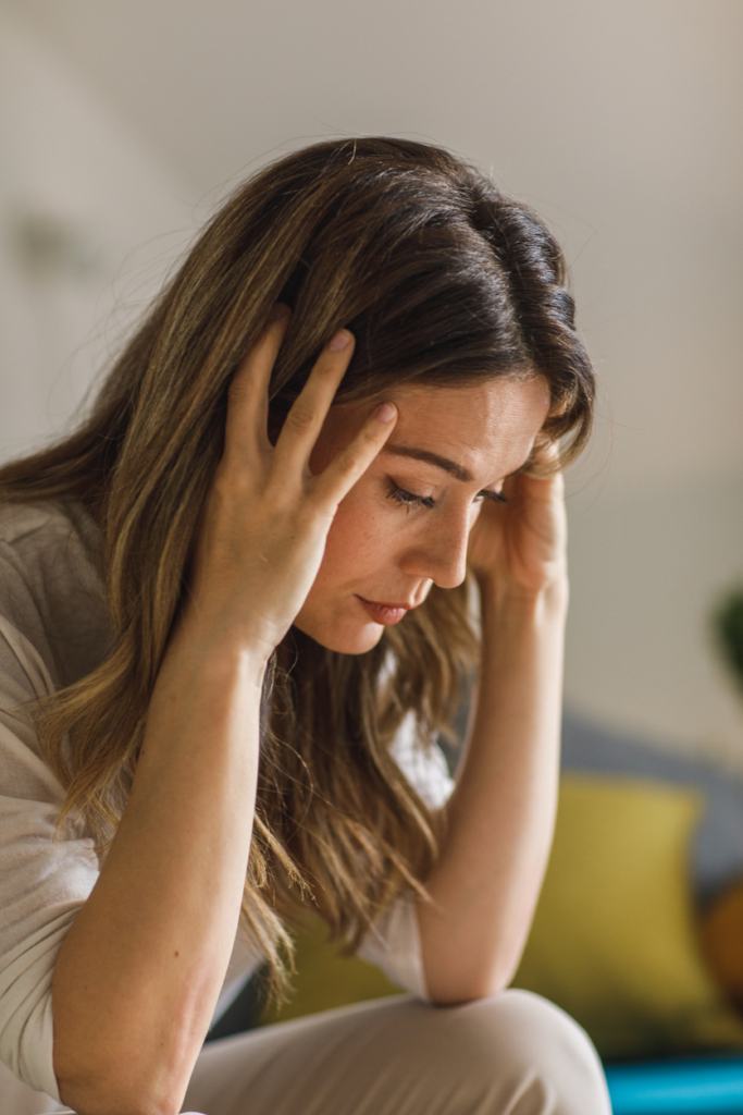 Nő fogja a fejét és elgondolkodik a jövő kérdéseiről