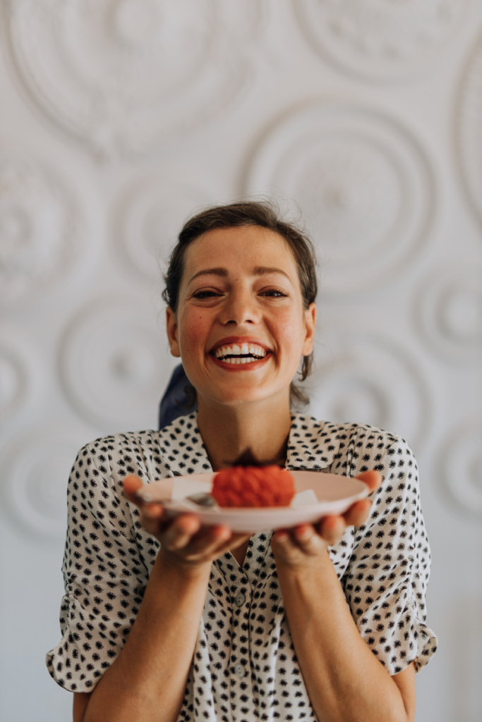 Nő egy kis süteménnyel a kezében