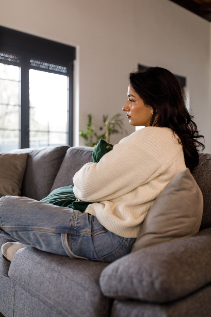 Fiatal lány csalódottan ül a kanapén