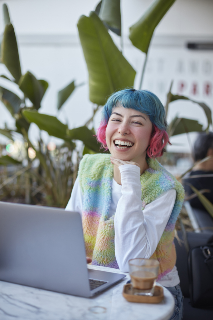 Fiatal, színes hajú munkavállaló a laptopnál