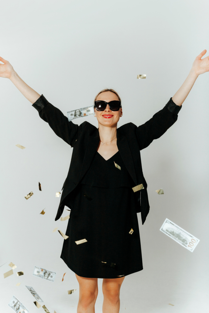 Nő áll a pénzesőben