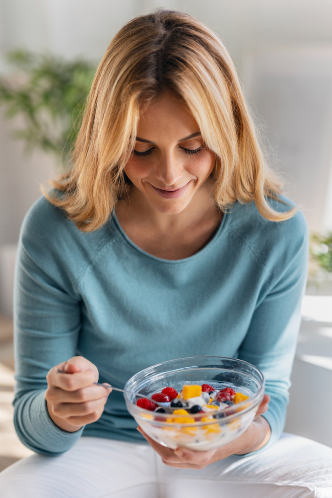 Nő egészséges, gyümölcsös reggelit fogyaszt