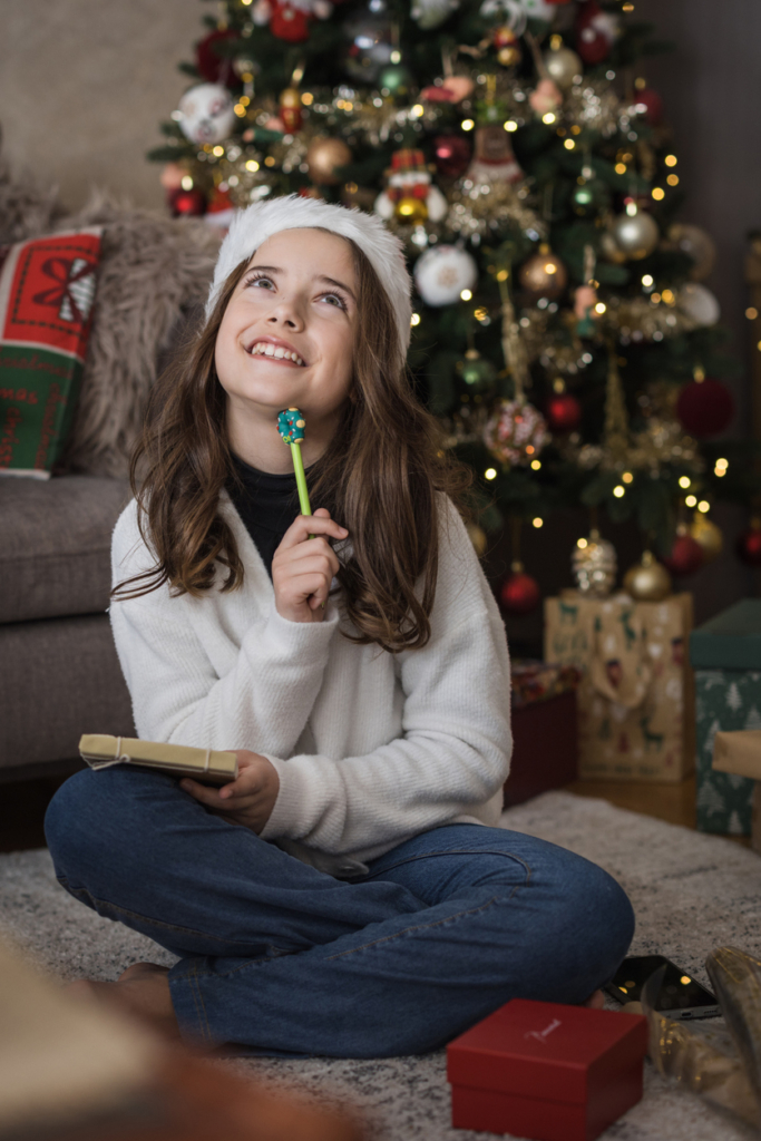 Kislány a karácsonyfa mellett ír a naplójába