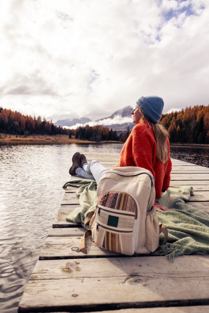 Nő élvezi a friss levegőt egy hegyi tó mellett