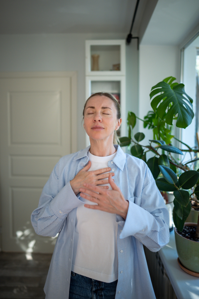 Nő mély lélegzetet vesz a nappaliban