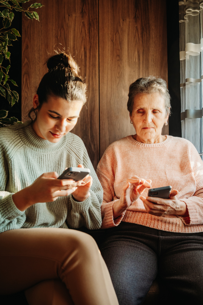 Nagymama és unokája együtt mobiloznak egy kávézóban