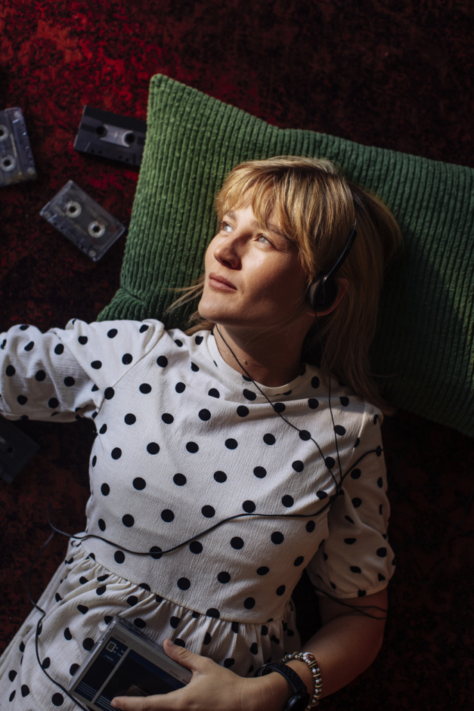 Nő hanyatt fekve zenét hallgat